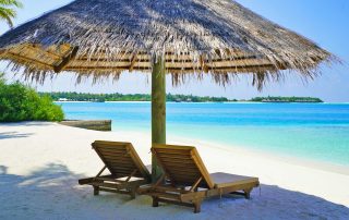 Lounge Chairs Under Thatched Umbrella at the Beach